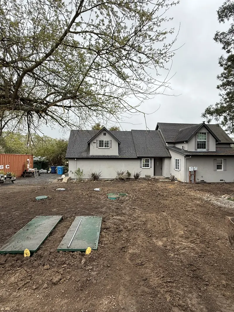 Completed septic system backfilled clean beside the home
