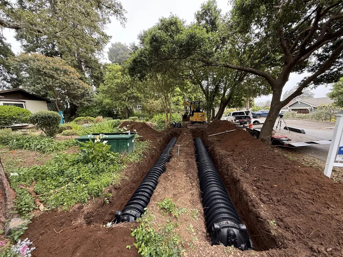 Leach field pipes set in trenches on a wooded lot