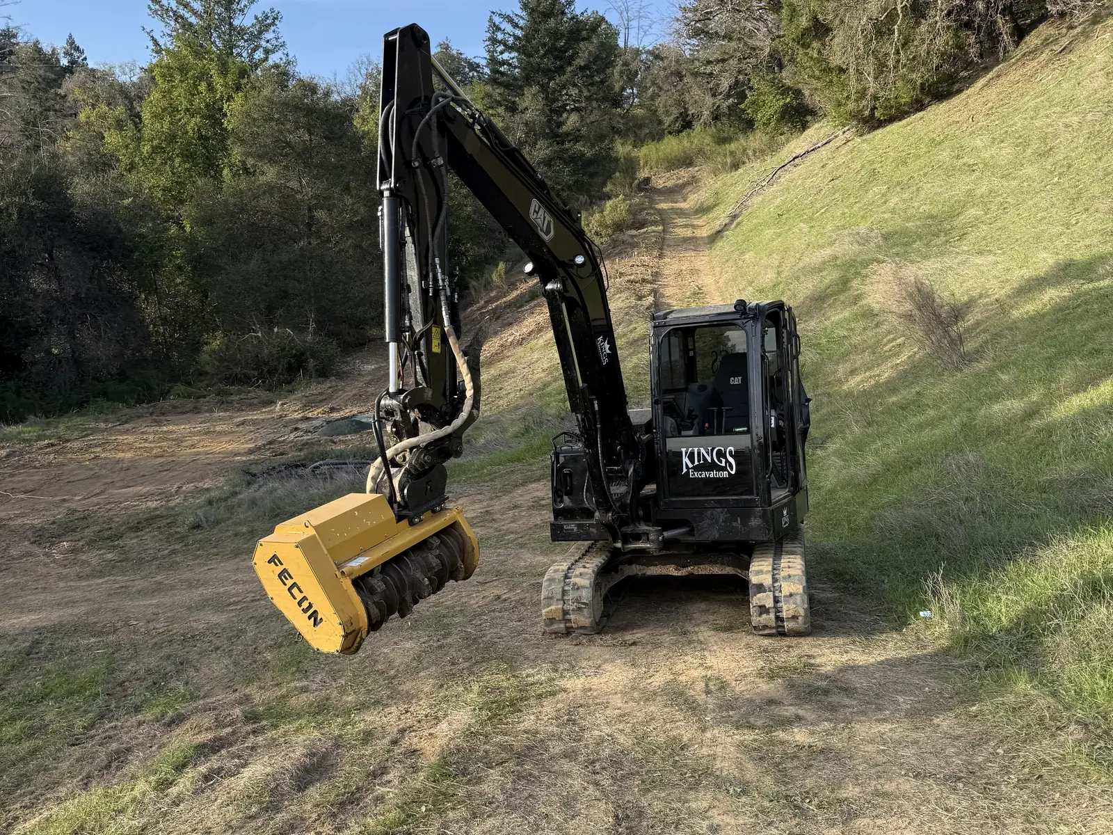 Kings excavator with a forestry mulcher head staged on a cleared hillside